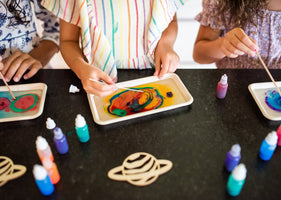 Children swirling marbling dyes for craft.