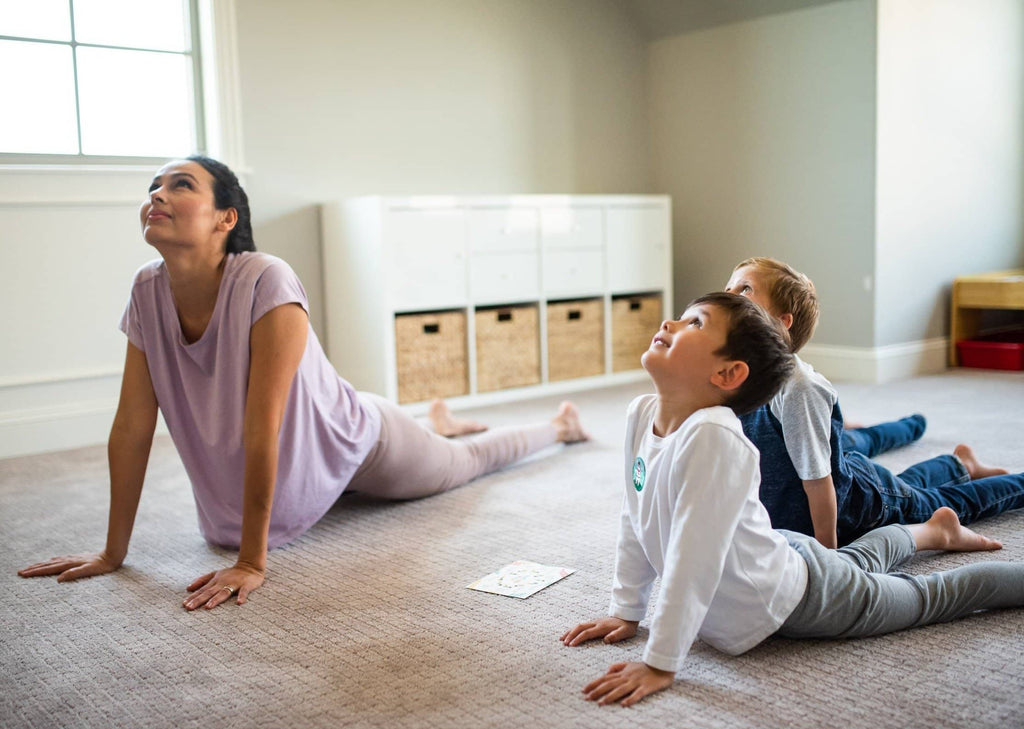 Mother and children enjoying kid's nature yoga together.